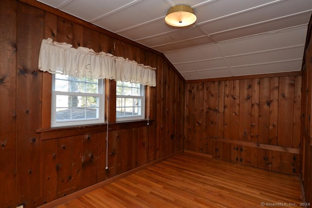 additional living space featuring wood walls and wood-type flooring