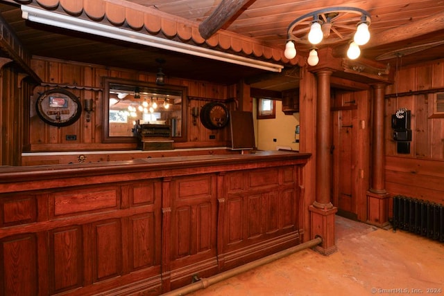 bar featuring wooden walls, hanging light fixtures, and radiator