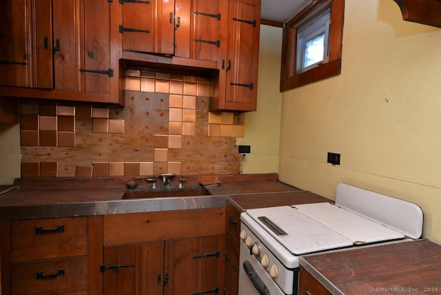 kitchen featuring electric range and backsplash