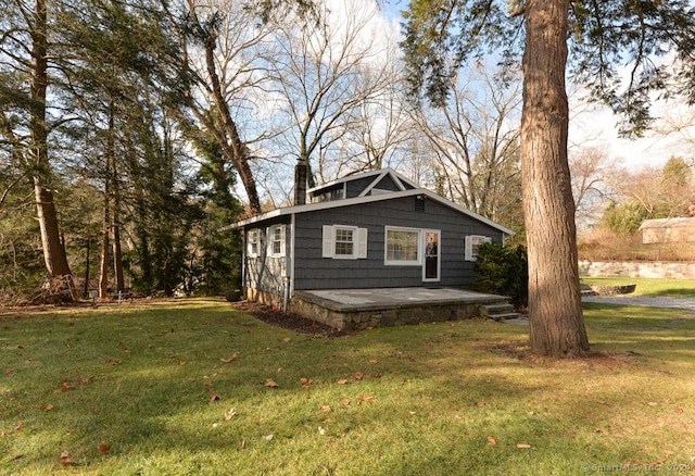 view of property exterior featuring a patio area and a lawn