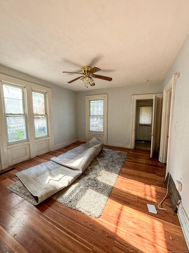 unfurnished room with hardwood / wood-style flooring, plenty of natural light, and ceiling fan