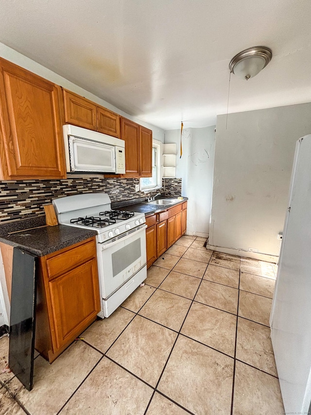 kitchen with decorative backsplash, white appliances, sink, and light tile patterned flooring