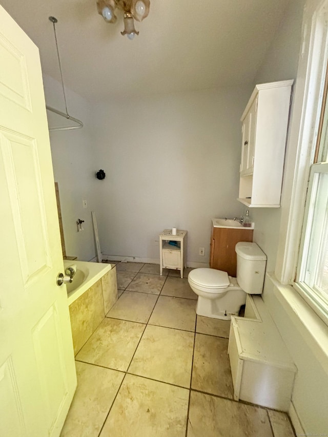 bathroom featuring tile patterned floors, toilet, and tiled tub