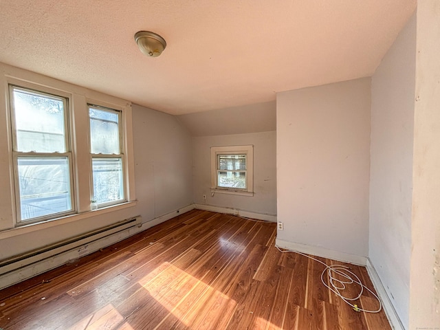 bonus room featuring a textured ceiling, dark hardwood / wood-style floors, vaulted ceiling, and a baseboard radiator