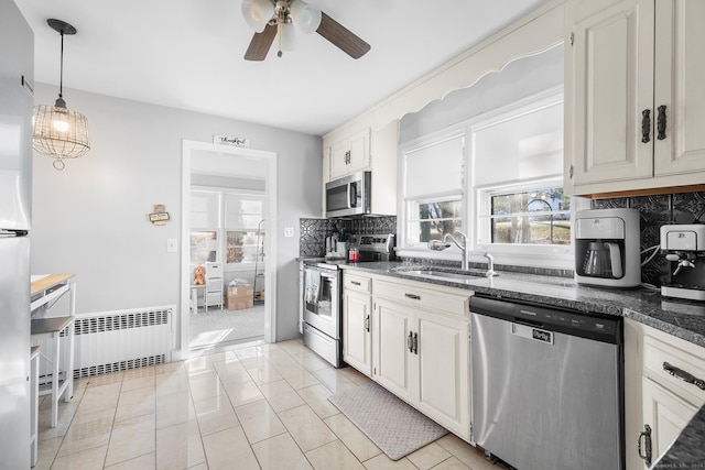 kitchen with white cabinets, sink, stainless steel appliances, and radiator