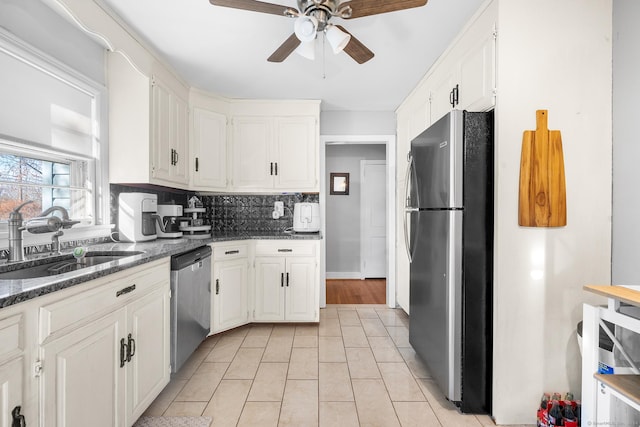 kitchen with white cabinetry, sink, stainless steel appliances, tasteful backsplash, and light tile patterned floors