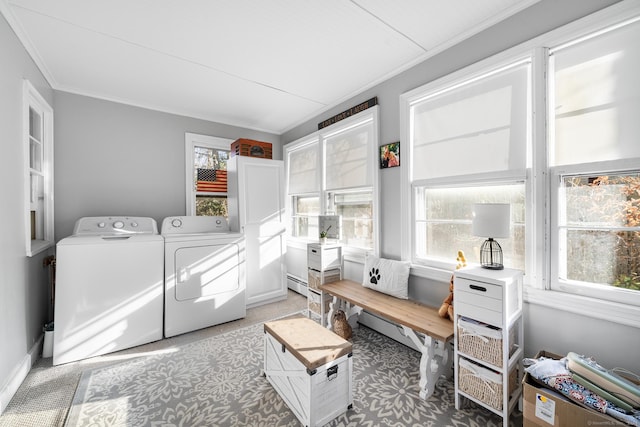 washroom featuring washing machine and clothes dryer, crown molding, plenty of natural light, and a baseboard radiator