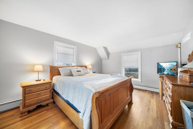 bedroom with light hardwood / wood-style floors, vaulted ceiling, and baseboard heating