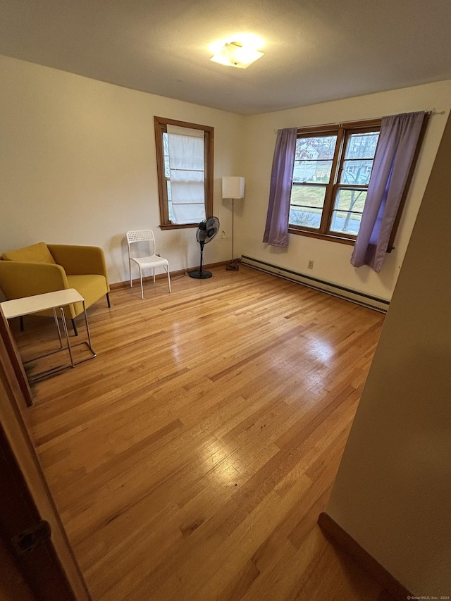 interior space featuring a healthy amount of sunlight, a baseboard radiator, and wood-type flooring