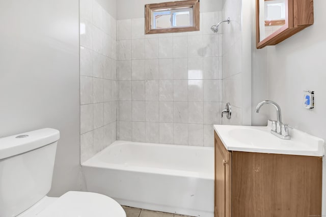 full bathroom featuring tiled shower / bath, tile patterned floors, vanity, and toilet