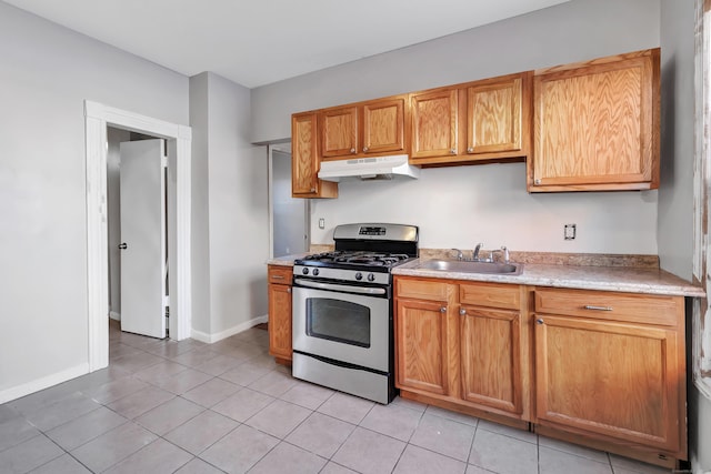 kitchen with light tile patterned flooring, gas stove, and sink