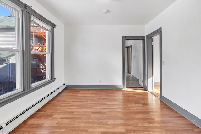 spare room with light hardwood / wood-style flooring and a baseboard heating unit