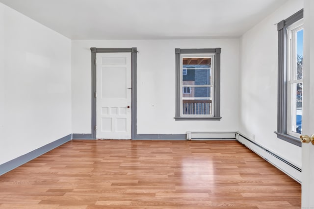 unfurnished room with light wood-type flooring and baseboard heating