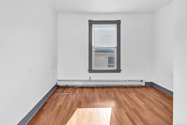 unfurnished room with hardwood / wood-style floors and a baseboard radiator