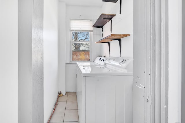 clothes washing area with washer and dryer and light tile patterned floors