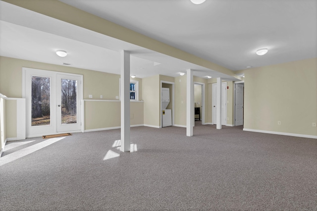 basement featuring carpet flooring and stacked washer and clothes dryer