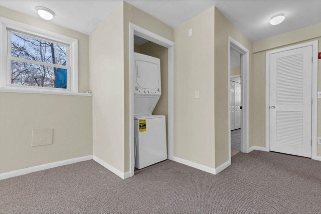 hallway with stacked washer / dryer and carpet floors