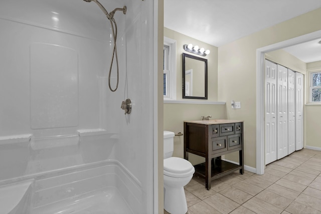 bathroom featuring tile patterned flooring, vanity, toilet, and walk in shower