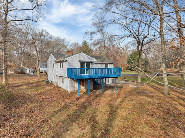 rear view of property with a wooden deck and central AC unit