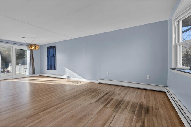 unfurnished room with a notable chandelier, light hardwood / wood-style floors, and baseboard heating