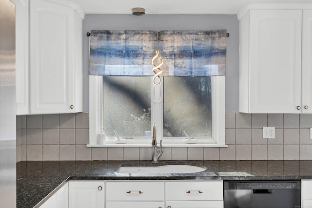 kitchen featuring backsplash, stainless steel dishwasher, dark stone counters, sink, and white cabinets