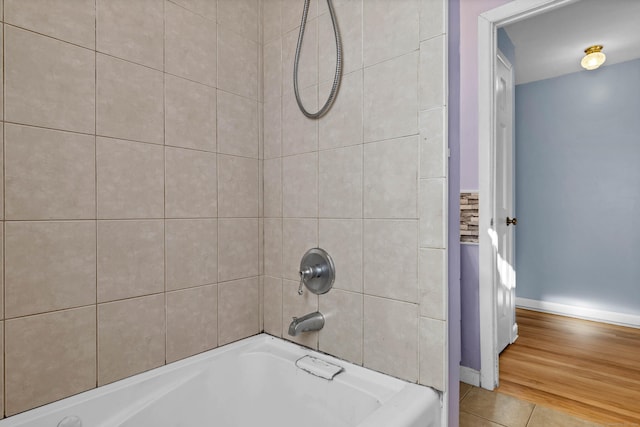 bathroom with hardwood / wood-style floors and tiled shower / bath combo