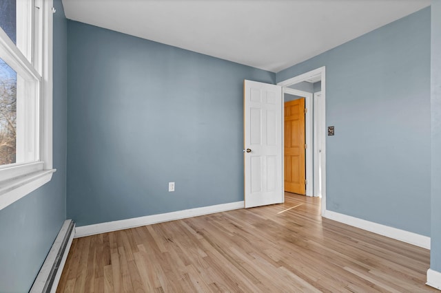 spare room featuring light hardwood / wood-style flooring and a baseboard radiator