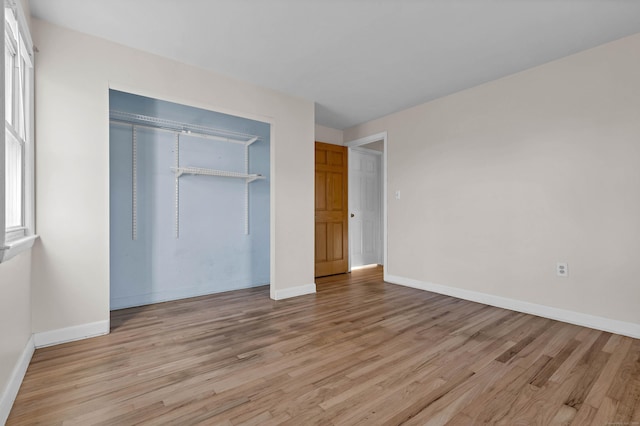 unfurnished bedroom featuring light hardwood / wood-style flooring and a closet