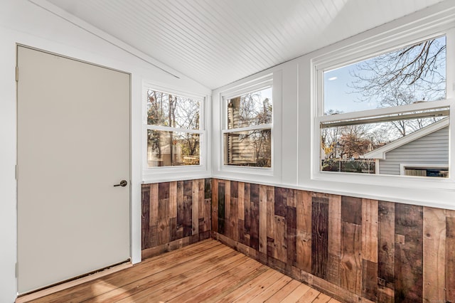 unfurnished sunroom featuring a healthy amount of sunlight and lofted ceiling