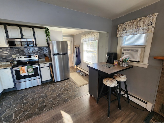 kitchen featuring dark hardwood / wood-style flooring, stainless steel appliances, and white cabinetry