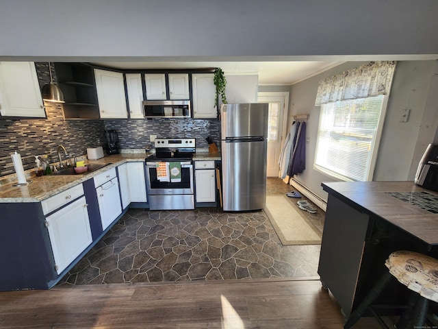 kitchen featuring white cabinets, sink, dark hardwood / wood-style floors, ornamental molding, and appliances with stainless steel finishes