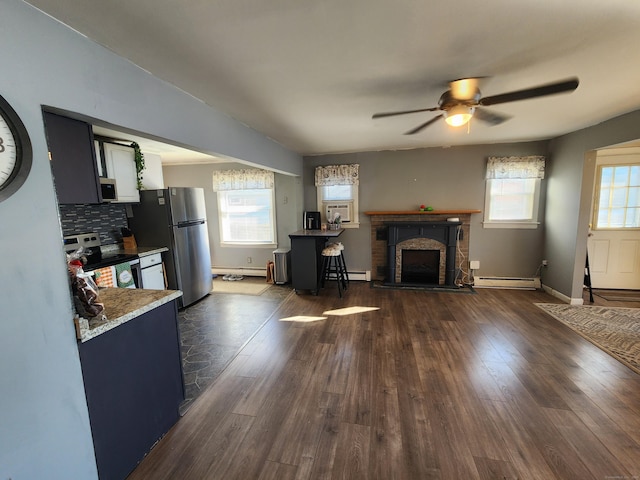 living room with plenty of natural light, dark hardwood / wood-style flooring, and baseboard heating