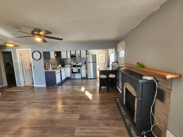 living room with dark hardwood / wood-style flooring, ceiling fan, and sink