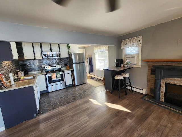 kitchen featuring a kitchen breakfast bar, dark hardwood / wood-style flooring, stainless steel appliances, and sink