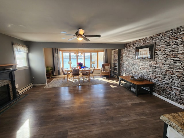 unfurnished dining area featuring a fireplace, plenty of natural light, dark hardwood / wood-style flooring, and a baseboard heating unit