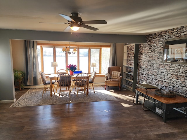 dining space with dark hardwood / wood-style flooring and ceiling fan with notable chandelier