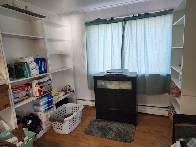 interior space with wood walls, baseboard heating, and dark wood-type flooring