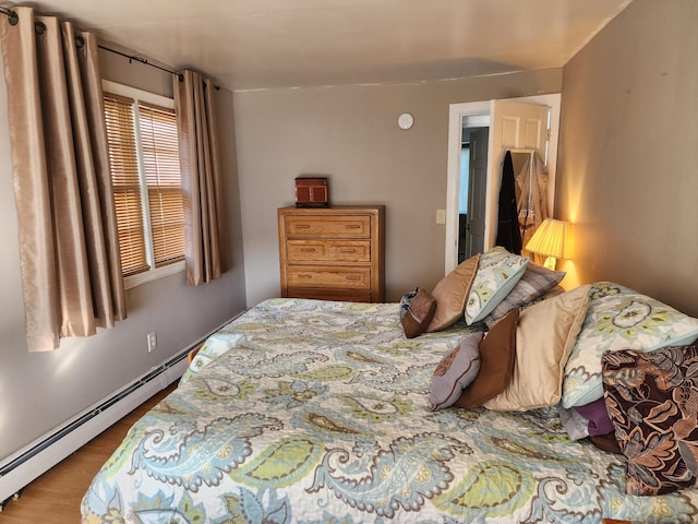 bedroom with hardwood / wood-style flooring and a baseboard radiator