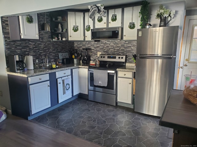 kitchen with tasteful backsplash, white cabinetry, dark wood-type flooring, and appliances with stainless steel finishes