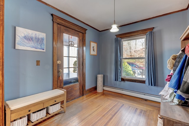 interior space featuring hardwood / wood-style flooring, crown molding, and a baseboard heating unit