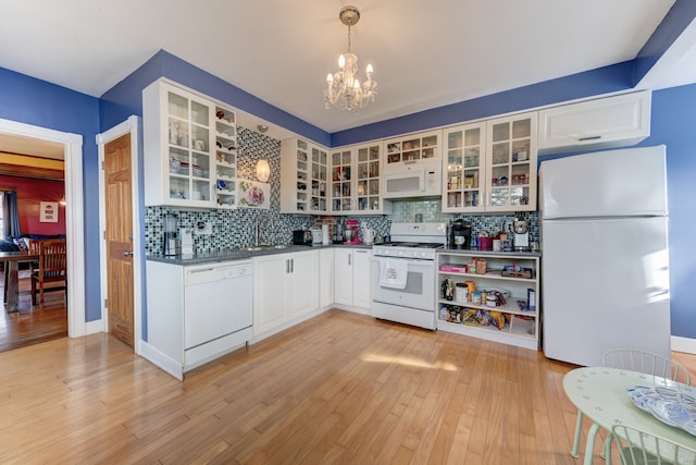 kitchen with white cabinetry, tasteful backsplash, light hardwood / wood-style flooring, pendant lighting, and white appliances