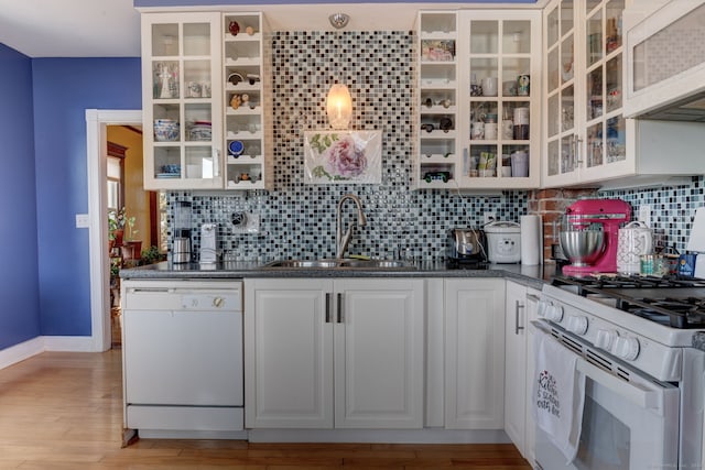 kitchen with white cabinets, backsplash, white appliances, and sink