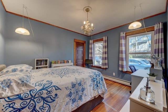 bedroom featuring hardwood / wood-style flooring, an inviting chandelier, crown molding, and a baseboard heating unit