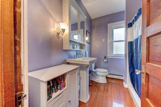 bathroom featuring curtained shower, sink, a baseboard radiator, hardwood / wood-style floors, and toilet