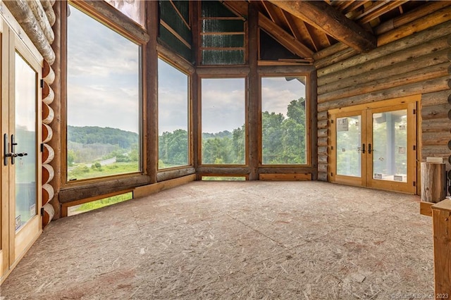 unfurnished sunroom with beam ceiling and french doors