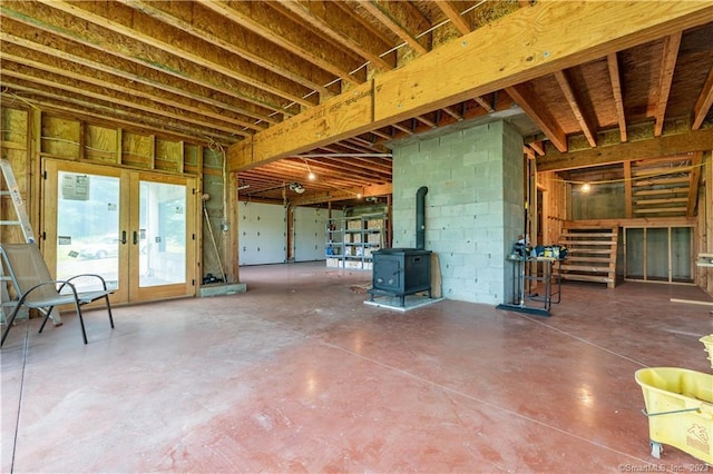 basement featuring french doors and a wood stove