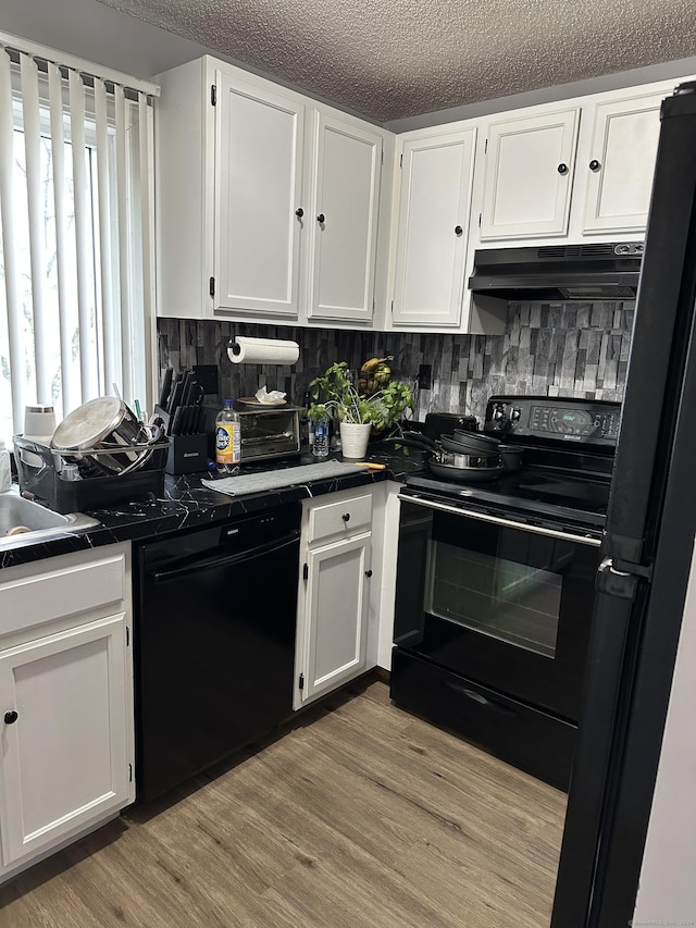 1259 E St Unit A, New Britain, CT 06053 - kitchen featuring black appliances, under cabinet range hood, white cabinets, backsplash, and a textured ceiling