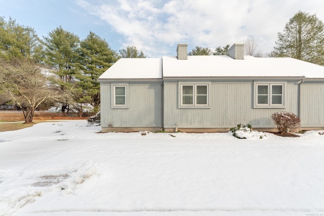 view of snow covered back of property