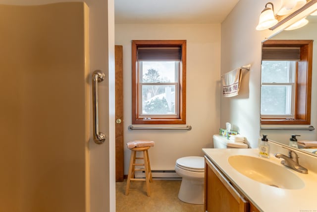 bathroom with vanity, toilet, and a baseboard heating unit