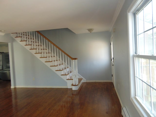 stairway with ornamental molding, a healthy amount of sunlight, a baseboard heating unit, and hardwood / wood-style flooring